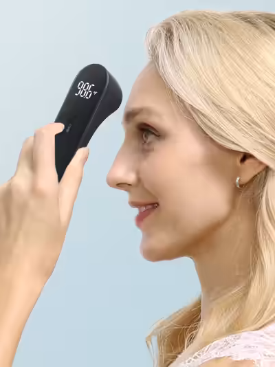 Женщина измеряет температуру бесконтактным термометром iHealth, направленным в лоб между бровями